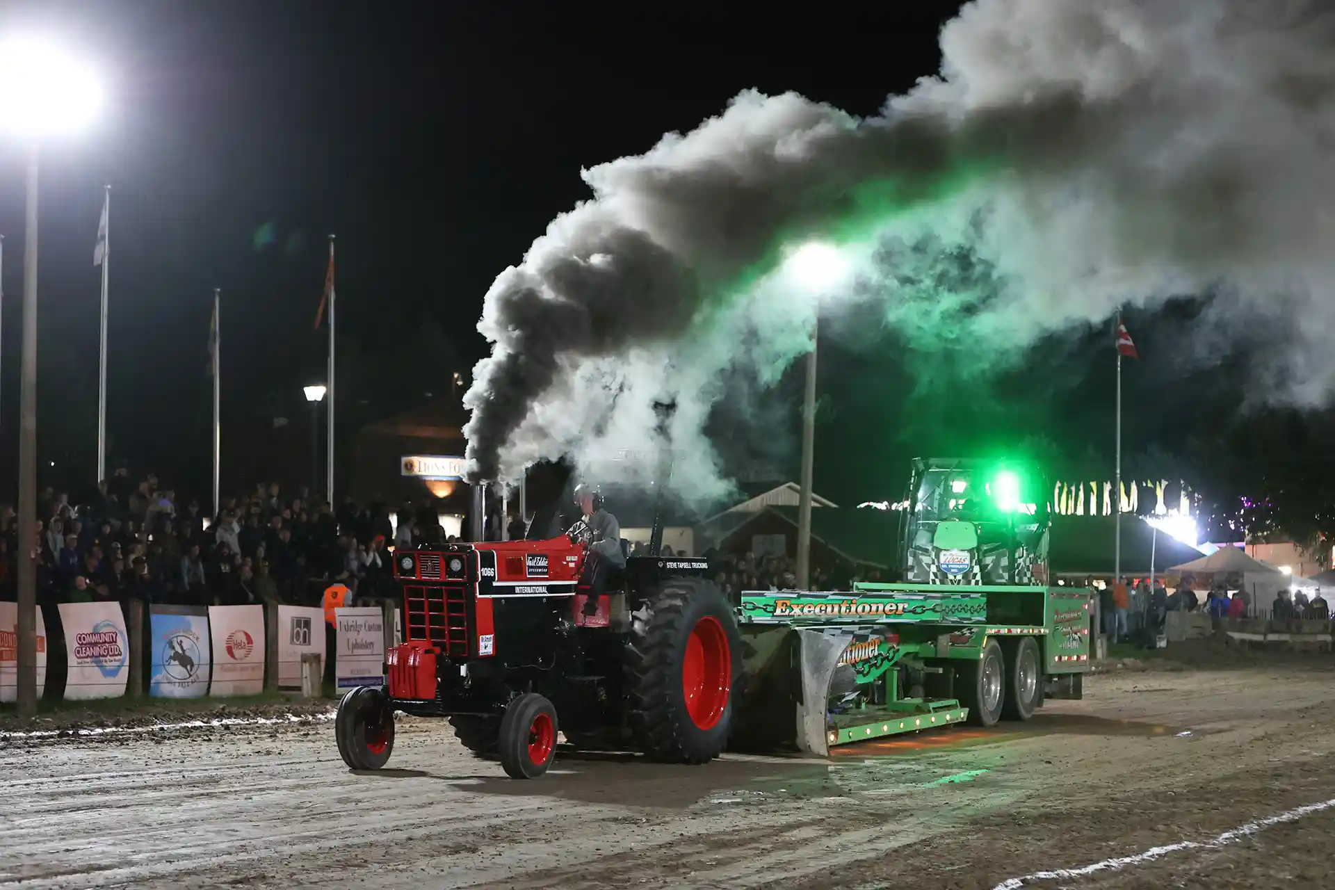 Local farm tractor pulling the sled at night